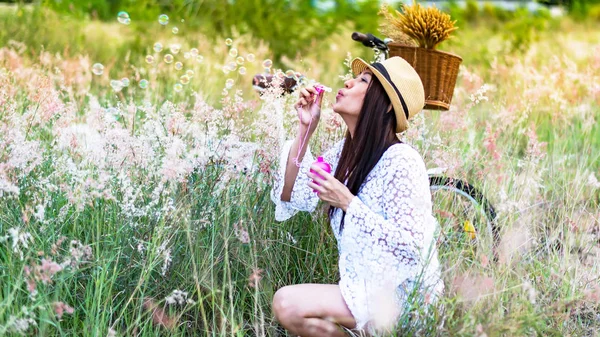 Woman blowing bubbles in meadow. travel and sunset