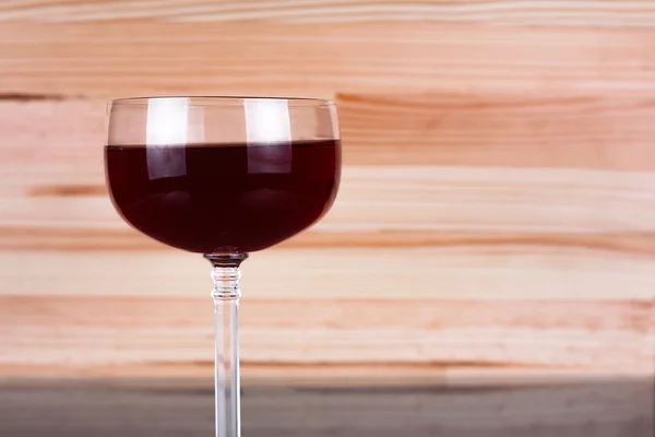 Glass of wine on natural wooden background.