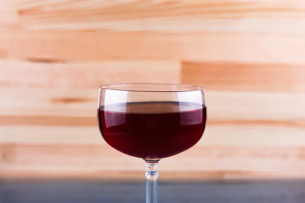 Glass of wine on natural wooden background.