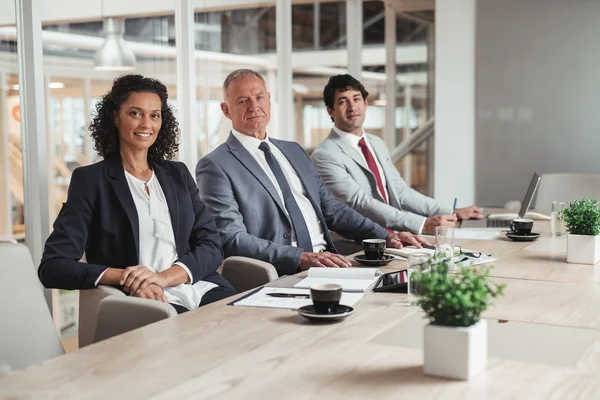 Business people sitting in row at table