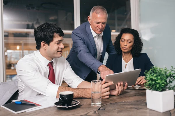 Business people talking together over tablet