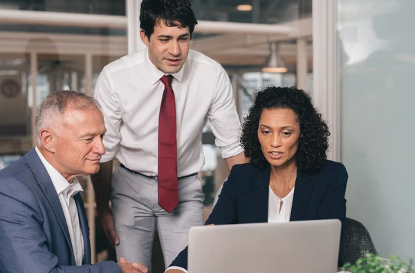 Business people talking together over laptop