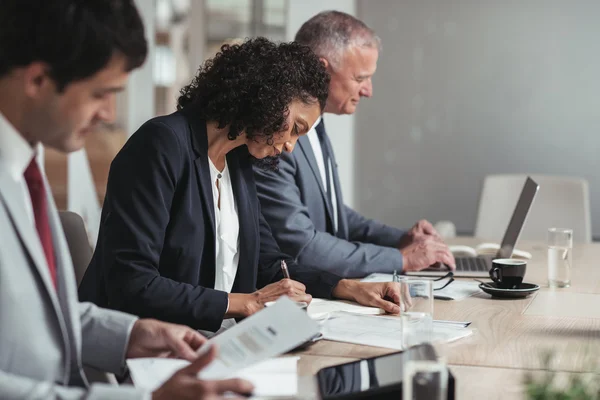 Business people working while sitting in row