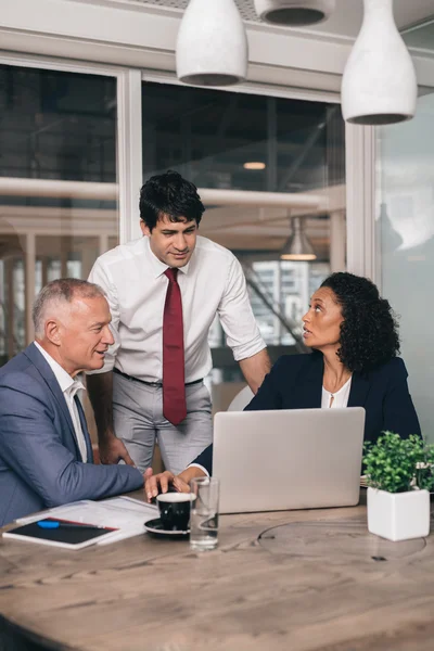 Business people talking together over laptop