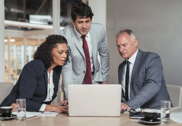 Business people talking together over laptop