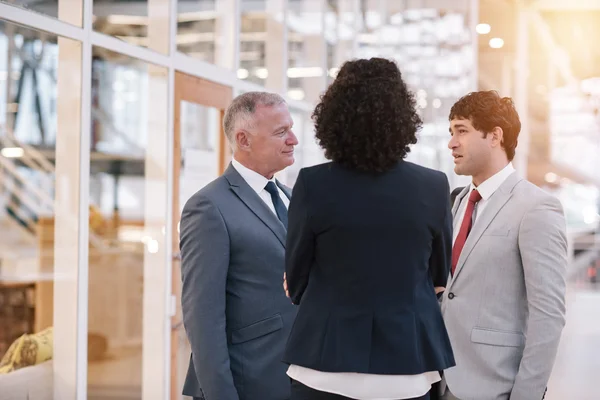 Business people talking together while standing in lobby