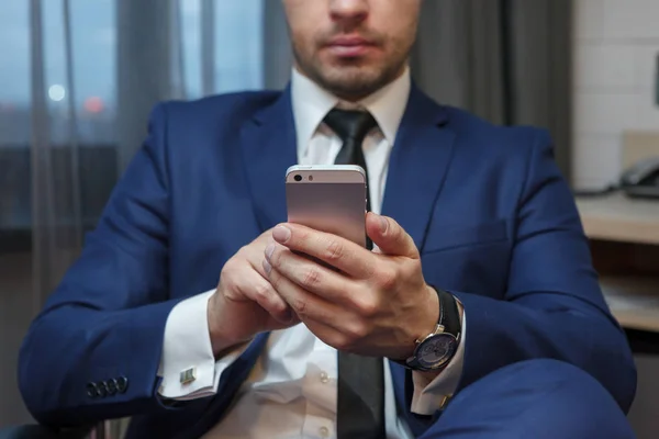 Young businessman holding the phone close-up