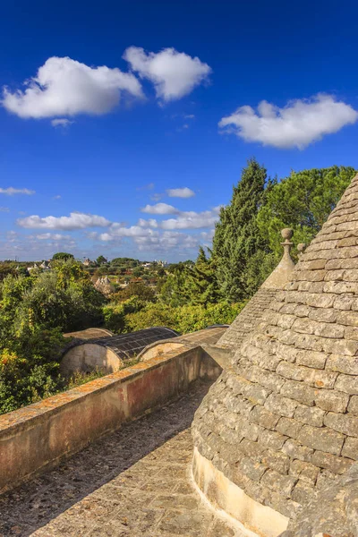 Italy landscape: Apulia countryside. Valle d\'Itria, territory of Cisternino. View from the roof of a trullo: hills with olive trees. Typical example of rural Apulian landscape.