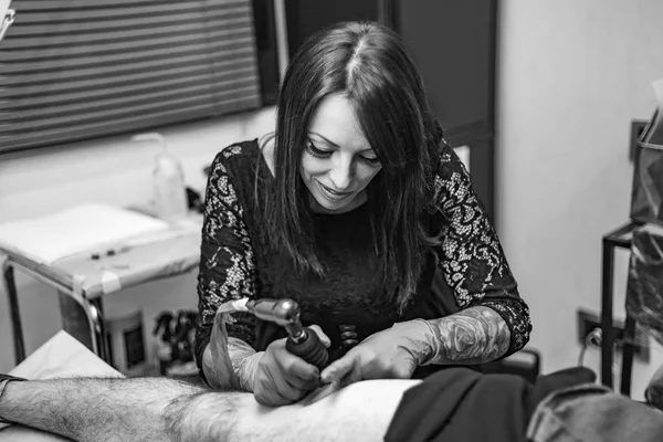 Portrait woman tattoo artist working tattoo. Black and white