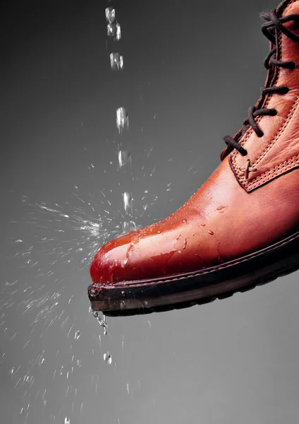 Leather boots waterproof protected brown color with water droplets. Shoes wax protect shoes from water