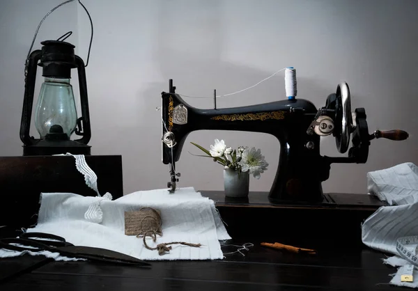 Classic retro style manual sewing machine ready for  work, kerosene lamp