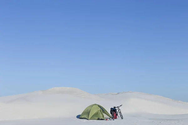 Camping in the desert with a backpack and tent.