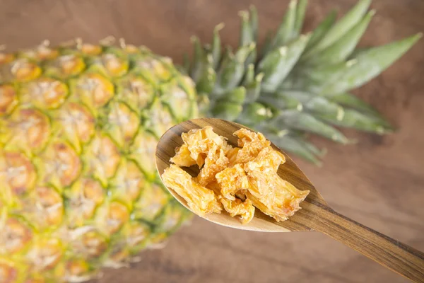 Dried pineapple on wooden spoon