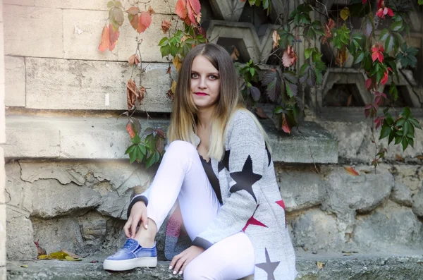 Full Length Portrait of Trendy Hipster Girl Standing at the Yellow Brick Wall Background. Urban Fashion Concept. Copy Space.