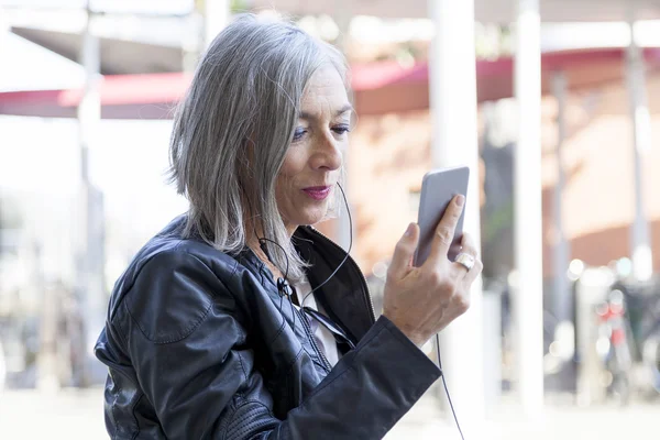 Elegant lady consults smartphone waiting for the train