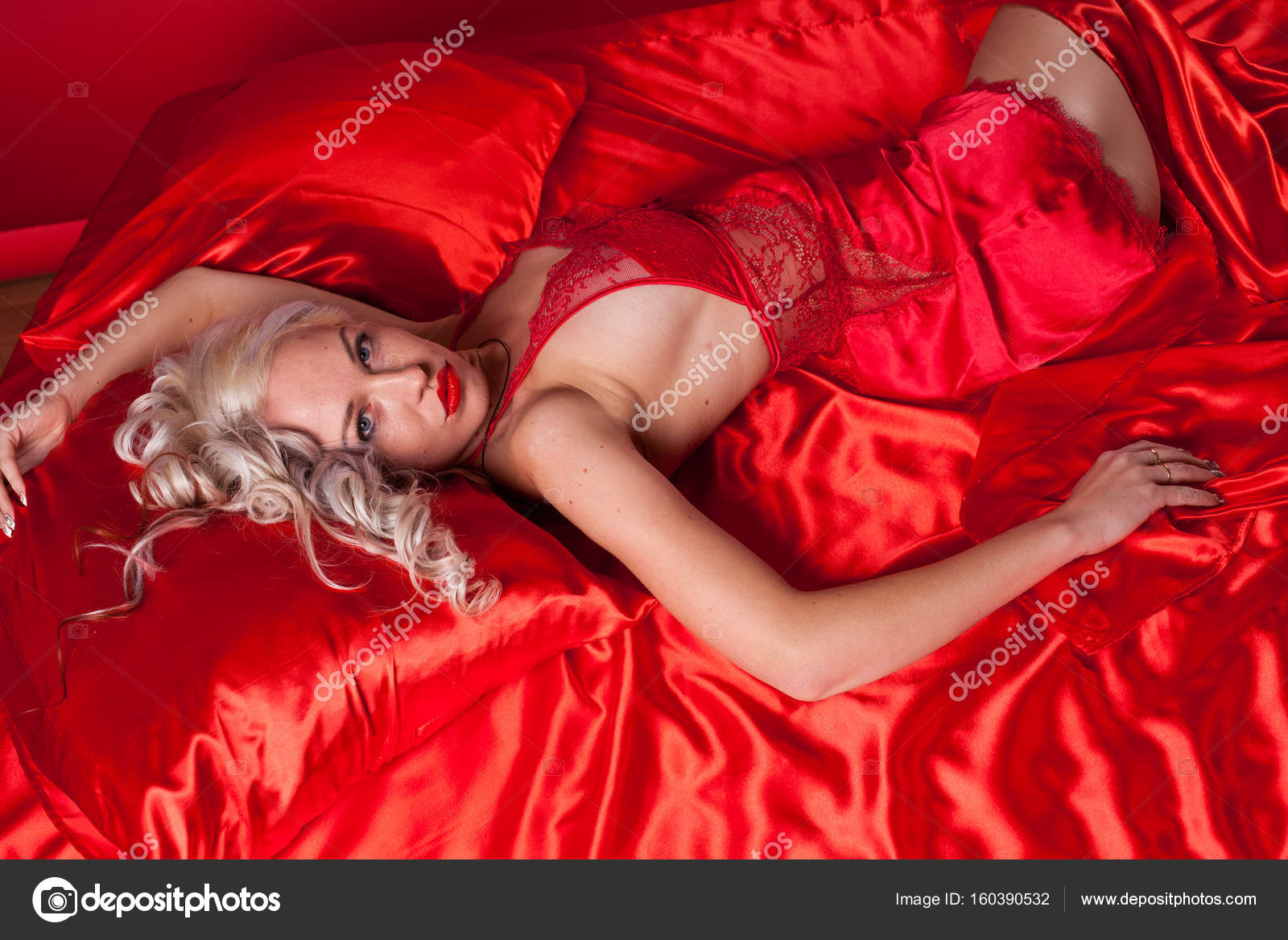 Горячая блондинка в красном белье мастурбирует на диване 