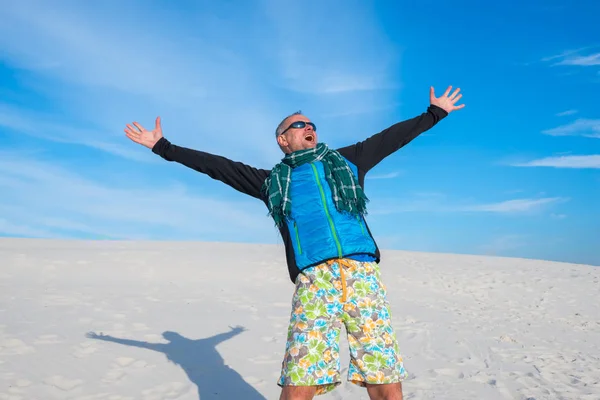 Happy man with arms outstretched by the desert
