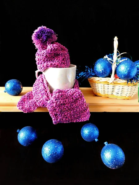 New Year composition made of mug, knitted kit  and Christmas tree decorations