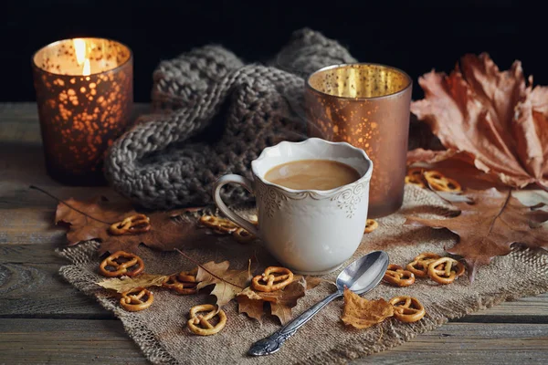 Autumn leaves, hot steaming cup of coffee and a warm scarf