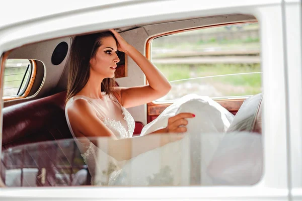 Tired bride sitting in a classic car