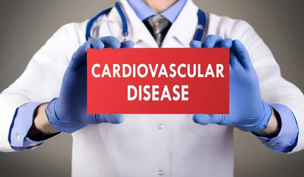 Doctor\'s hands in blue gloves shows the word cardiovascular disease. Medical concept.