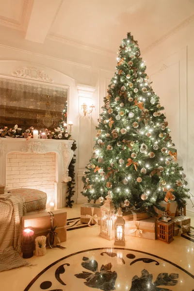 Christmas evening by candlelight. classic apartments with a white fireplace, decorated tree, bright sofa, large windows