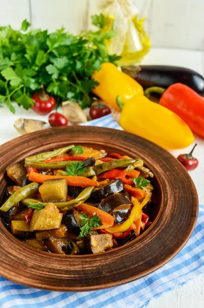Vegetable stew (salad): bell pepper, eggplant, asparagus beans, garlic, carrot, leek. Bright spicy aromatic dishes. Menu of Italian cuisine.