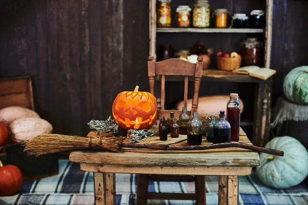 Old wooden table, hallowen pumpkin, dried herbs and bottles, a top view, in the studio, in the afternoon.