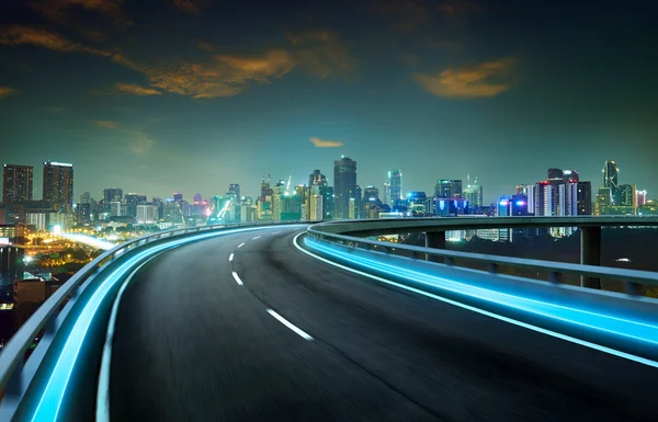 Neon light highway over cityscape