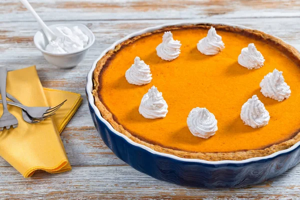Delicious bright orange pumpkin open pie in baking dish