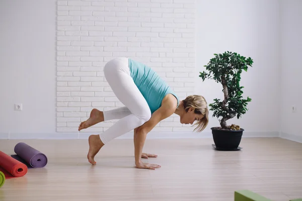 Young girl in a blue t-shirt doing yoga at home. wellness concept