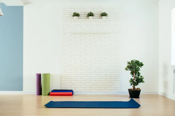 Yoga room with mat and white brick wall
