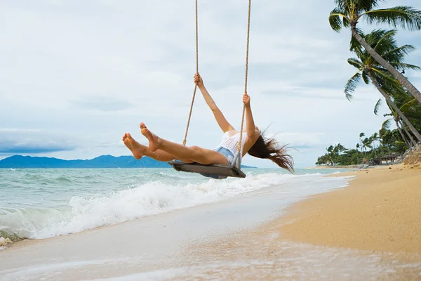 Young woman  swing on a beach swing.