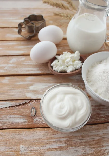 Ingredients for baking - milk eggs cheese nuts flour wheat, wood background