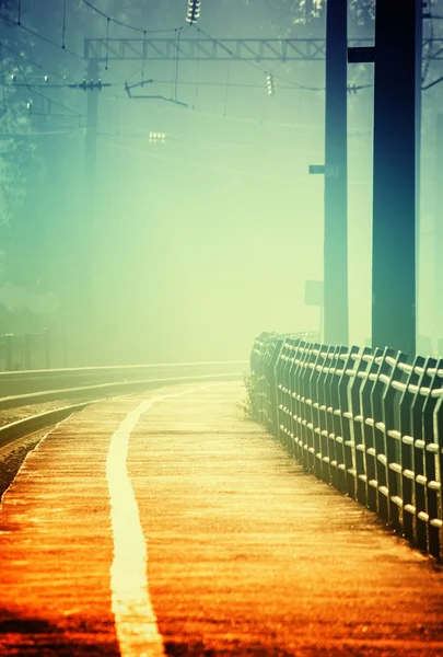 Railway rails stretching into the fog