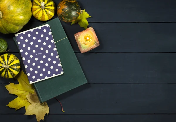 The book, notepad, pumpkins and autumn leaves