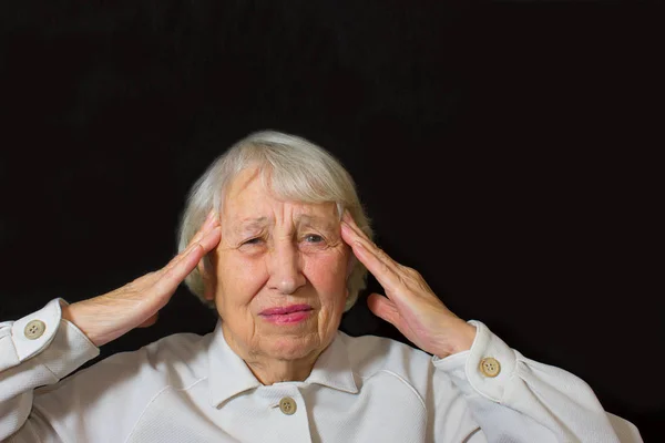 Senior Woman With Head In Hands Looking Weary