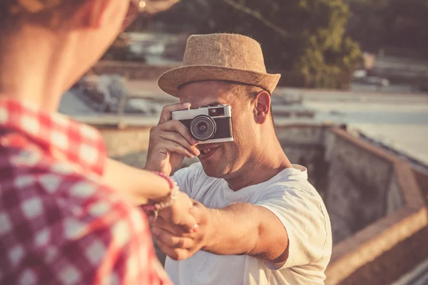 Couple taking photos with retro camera outdoors