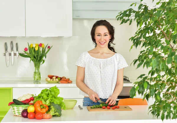Woman making salad in kitchen. Healthy eating lifestyle concept.
