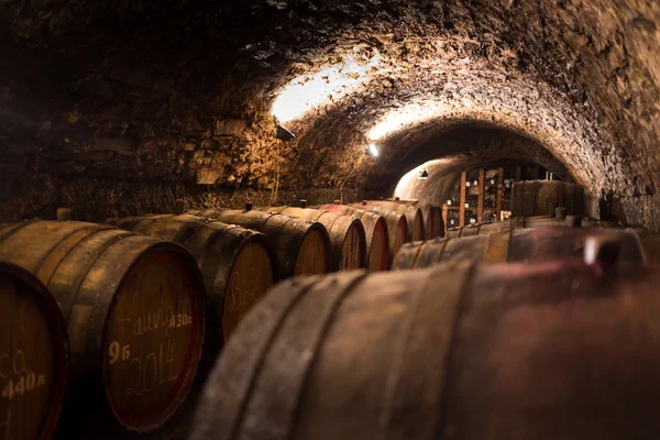 Old wooden barrels with wine in a wine vault, aged traditional w