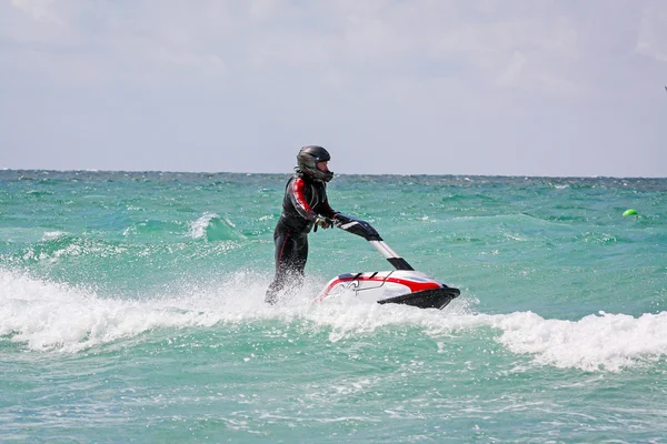 Popovka, Ukraine - August, 2012. Young Man on Jet Ski. Professional jet ski rider. Jet Ski Championship. Jetski performs many tricks on the waves.