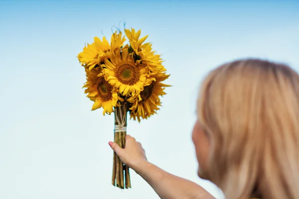 Young girl holding a bouquet of sunflowers
