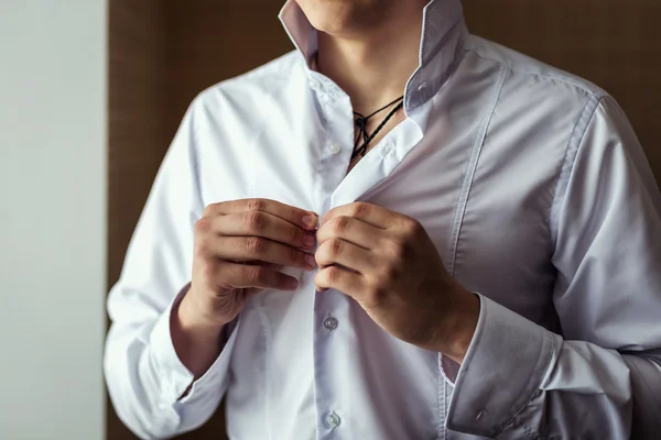 Businessman dress shirt. The man in the white shirt in the window dress cufflinks. Politician, man\'s style, Businessman buttoning his shirt,male hands closeup, American, European businessman