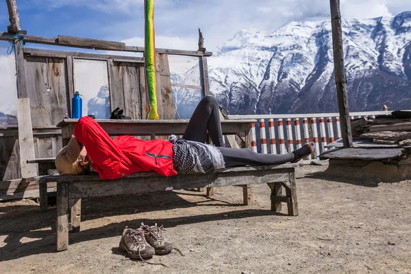 Beautiful Woman Traveler Backpacker Take Rest Mountain Terrace Village.Young Girl Sleeping Bench.North Snow Peaks Landscape Background. Cloudy Sky.