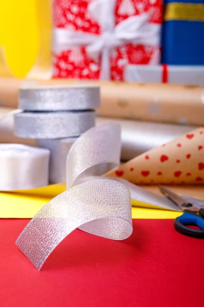 Gift wrapping, boxes, paper, ribbon and scissors on color background. Materials  accessories for  presents. Close up.
