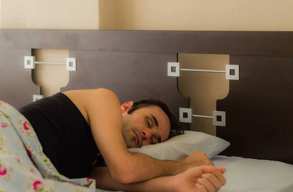 Man comfortably sleeping in his bed in the morning
