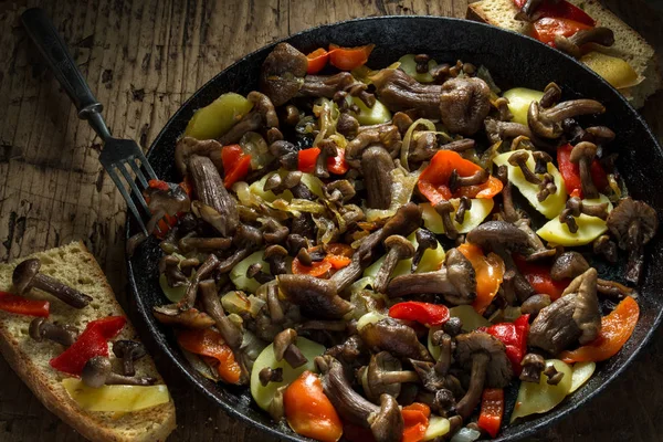 Mushrooms fried with onions and potatoes in the pan.