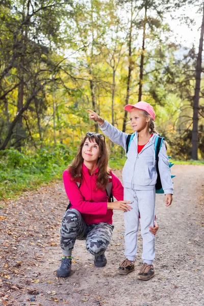 Mother walking with her child in warm sunny autumn day