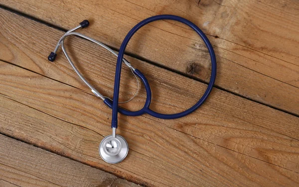 Closeup of a medical stethoscope, isolated on wooden background