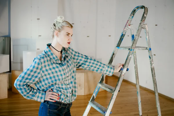 Girl and construction ladder. studio shot of a young woman with a construction ladder in the room